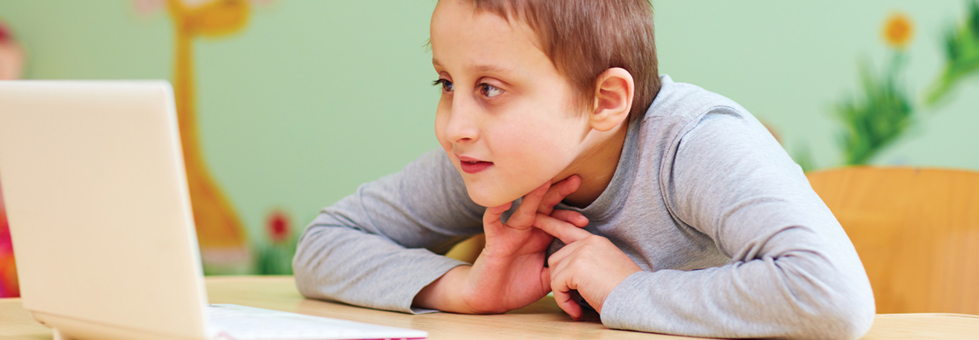 Young boy with special needs using laptop
