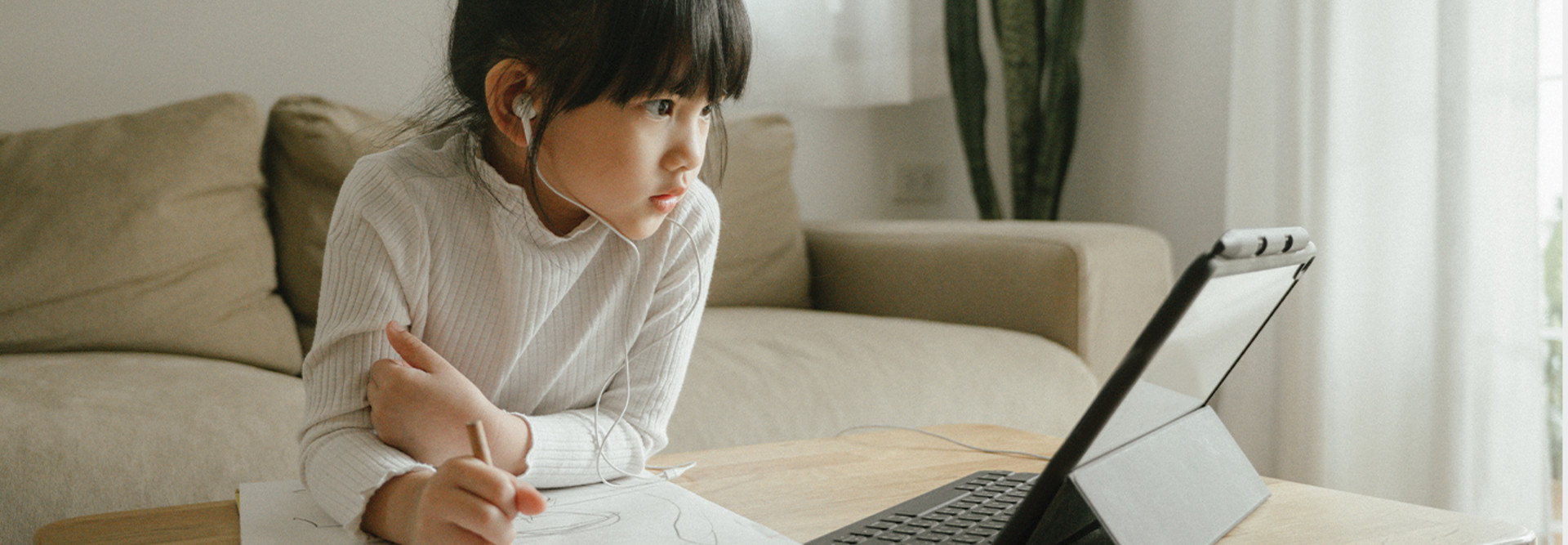 little girl doing schoolwork from home with a digital tablet