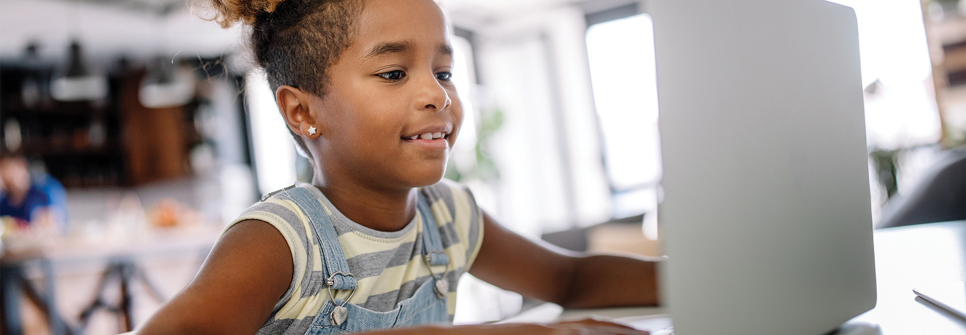 young girl using laptop for schoolwork at home