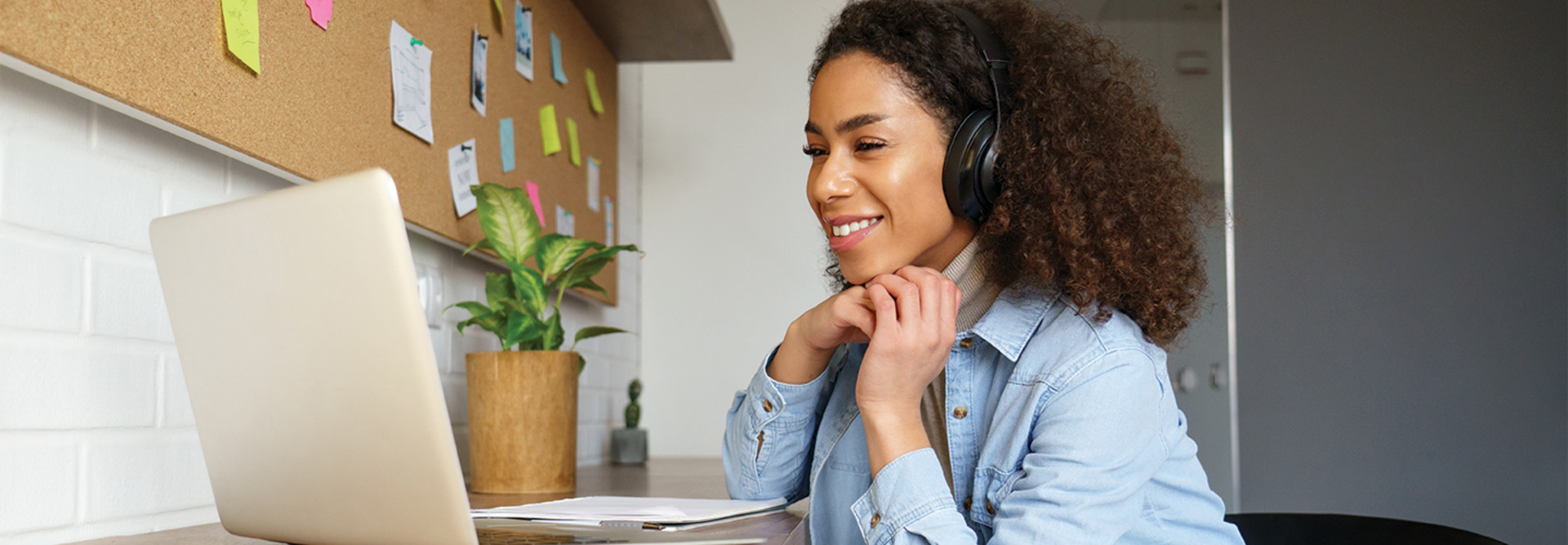 woman with headphones looking at a laptop