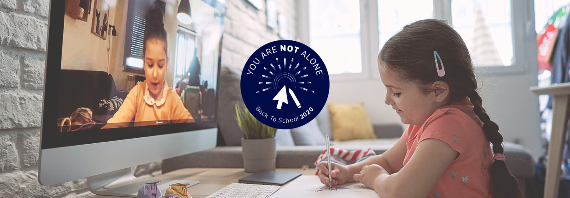 two young girls doing homework online together 