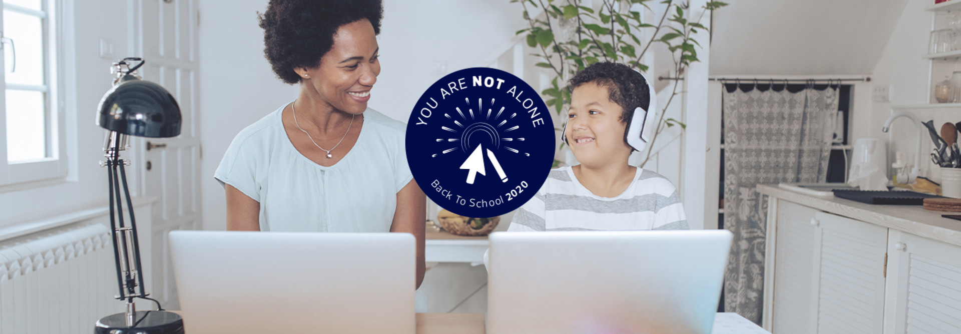 mother helping young son with online learning