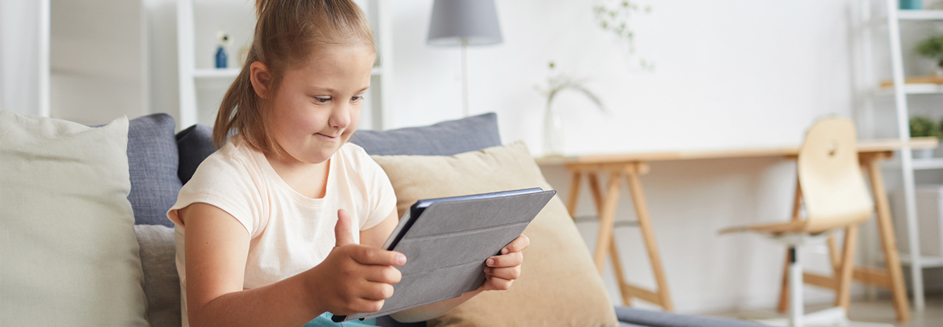 young girl with disability using tablet at home