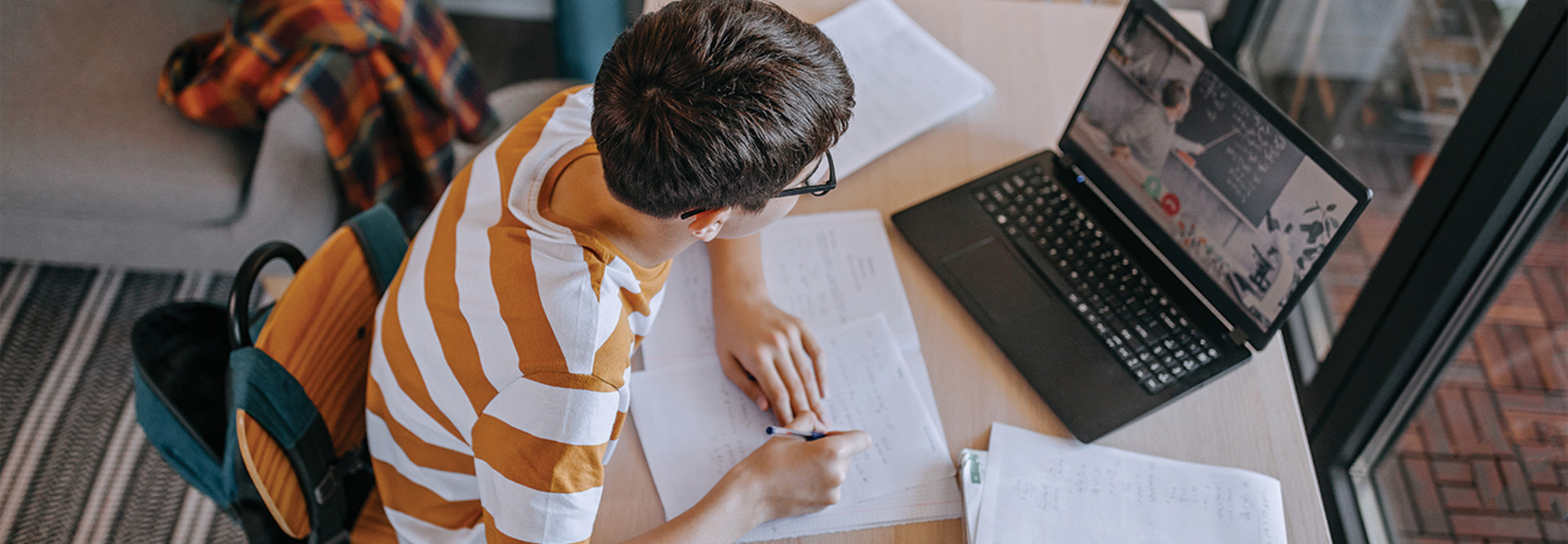 boy using laptop at home for remote learning