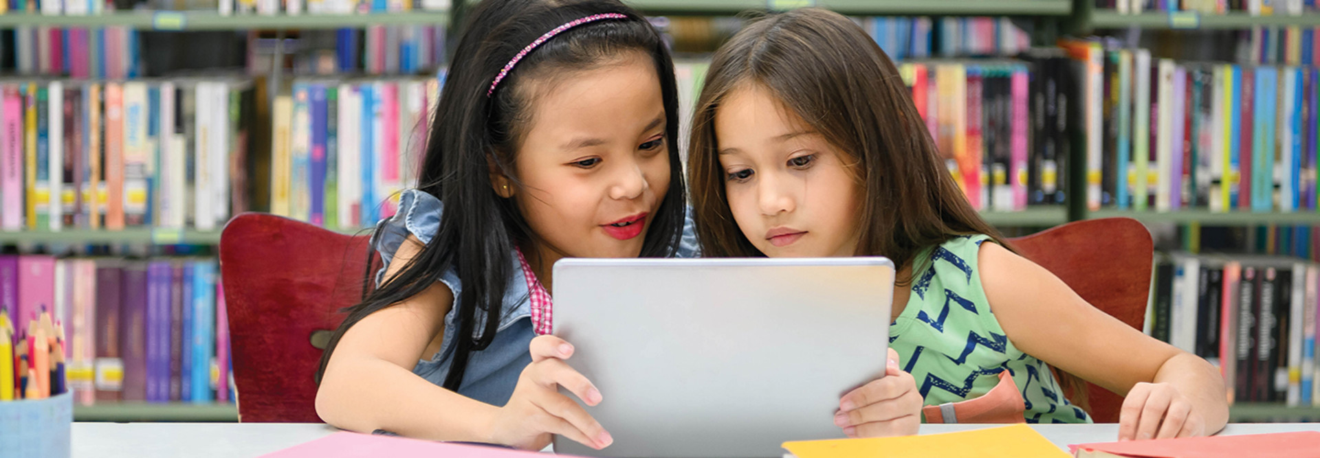 Two girls using tablet for remote learning