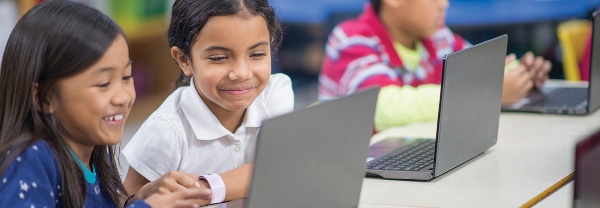 Two kids remote learning on laptops 