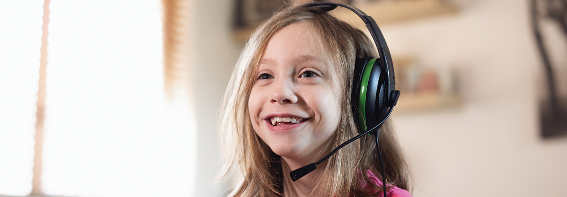 young girl smiling with gaming headset on 