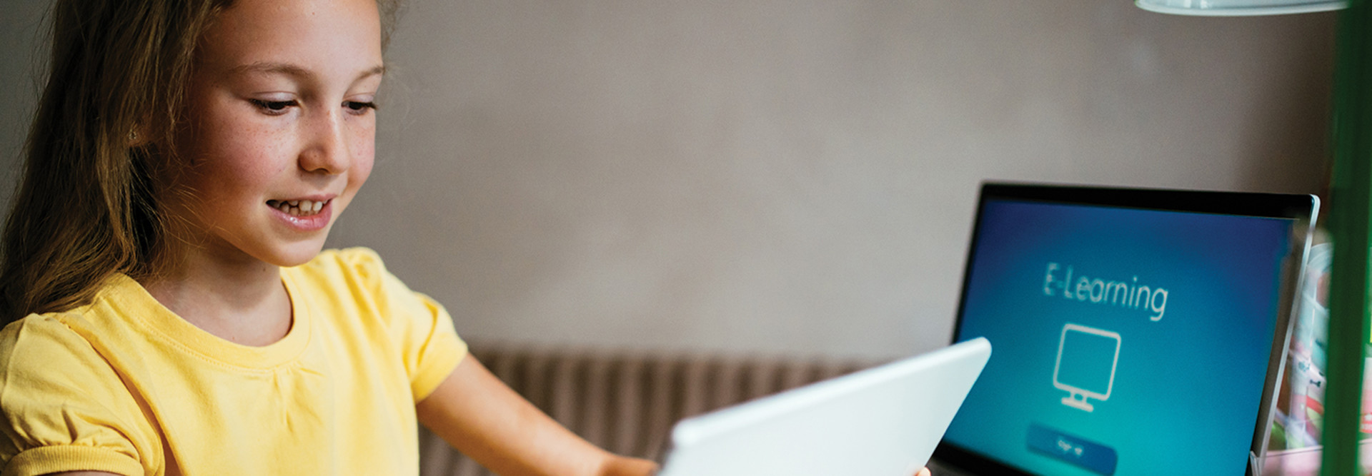 Girl on tablet and computer for e-learning