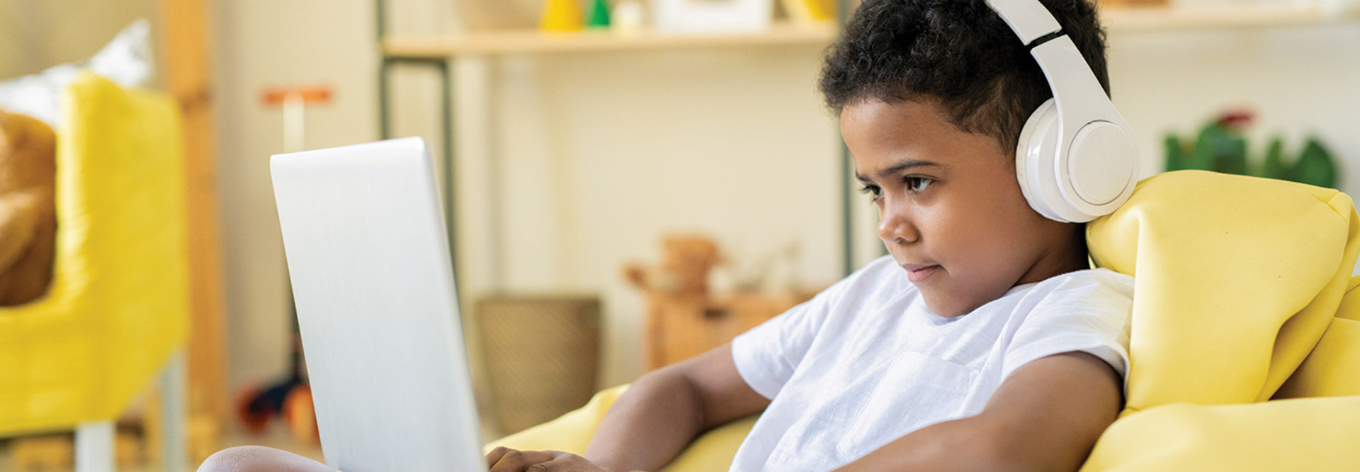 Boy with headphones looking at computer screen 