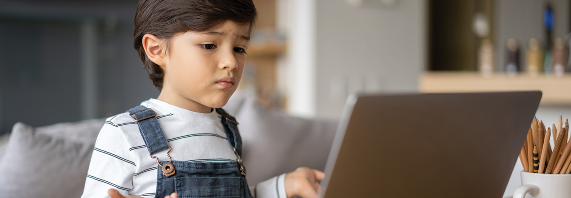 young boy looking at laptop screen for e-learning