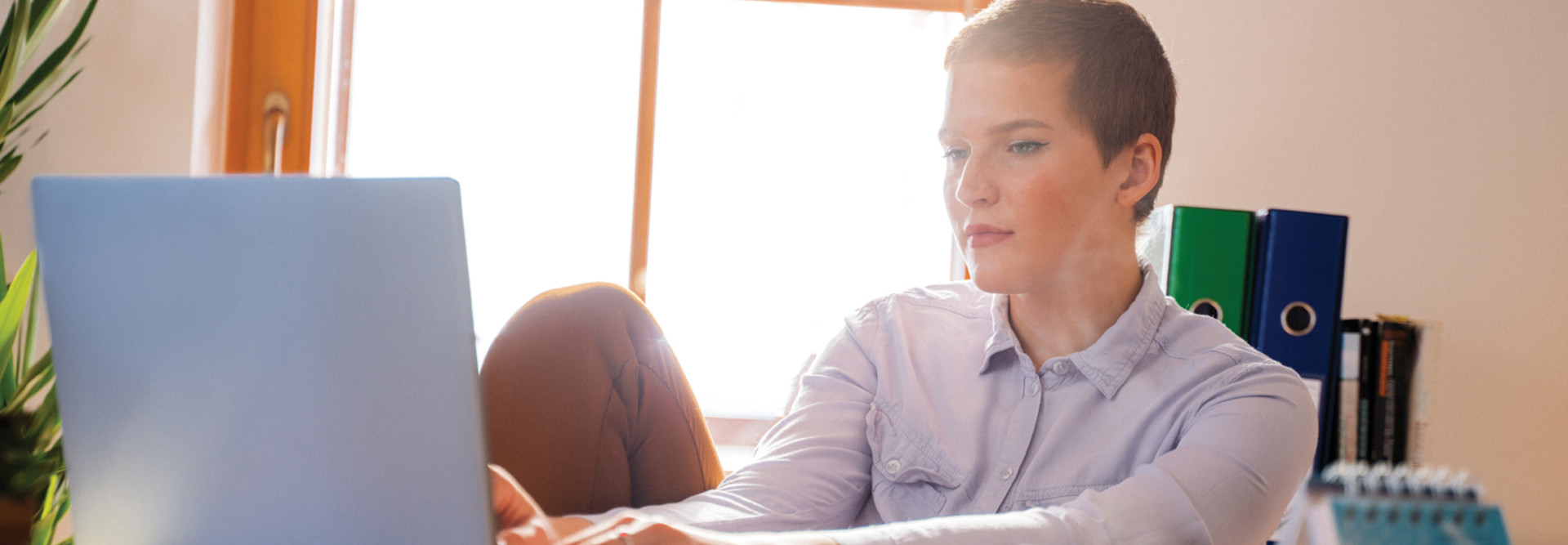 IT leader on her laptop in front of a bright window