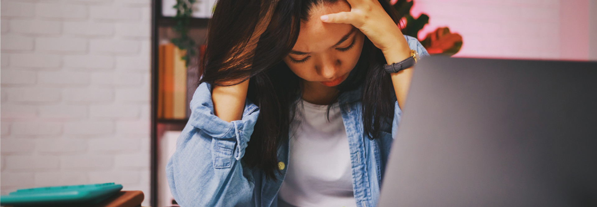 Student with head in hands at computer - content filtering