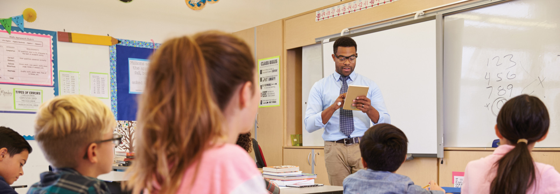 Male teacher standing in front of K-12 class - artificial intelligence support