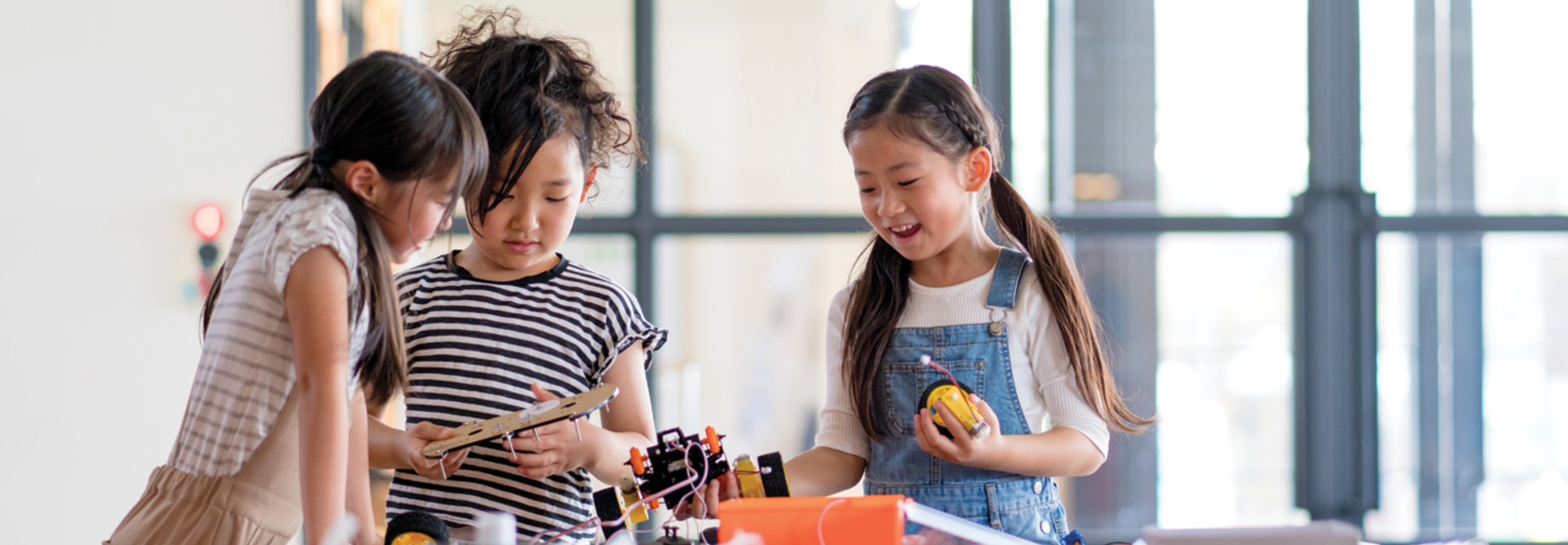 three k-12 students working together on a robotics project