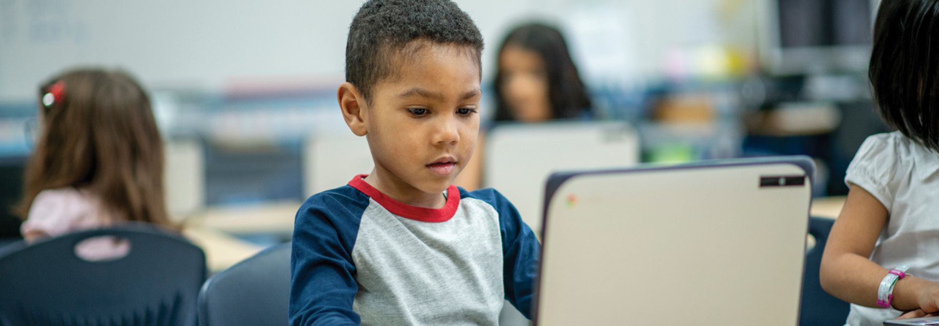 K–12 student using laptop device in classroom for learning