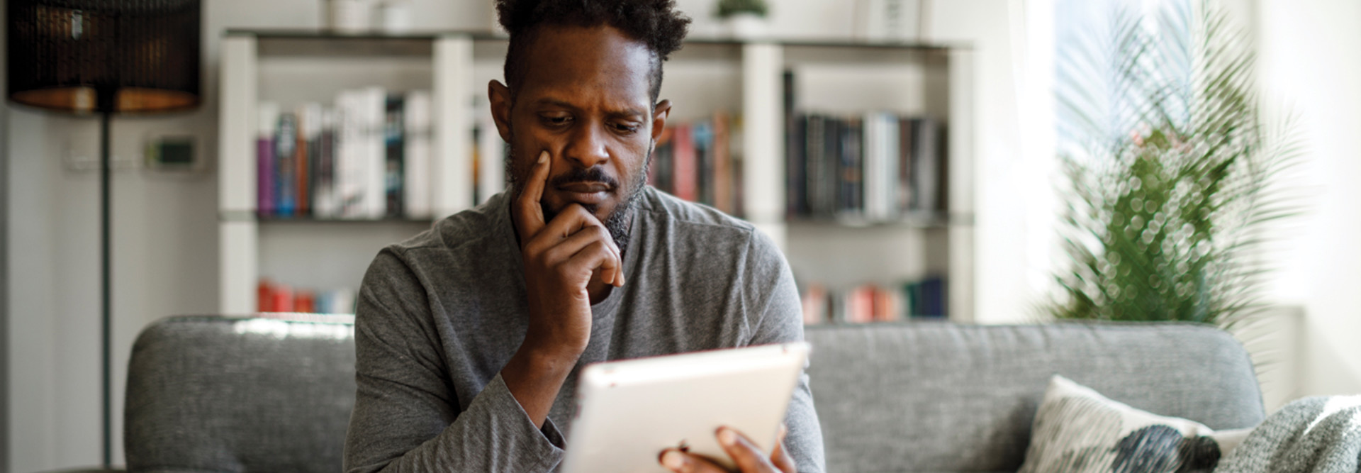 Man looking suspiciously at tablet 