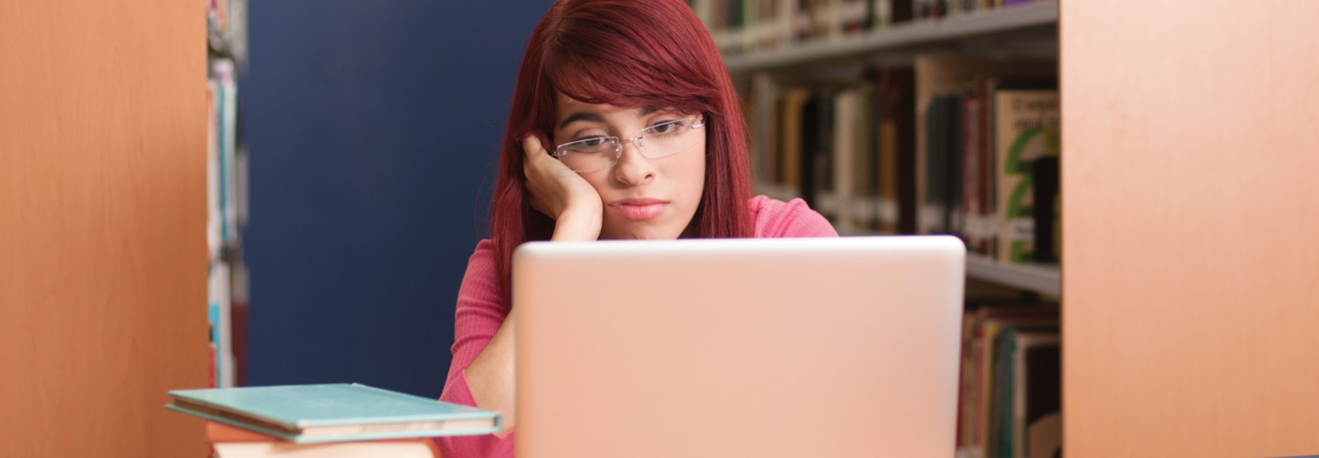 sad student on laptop in library