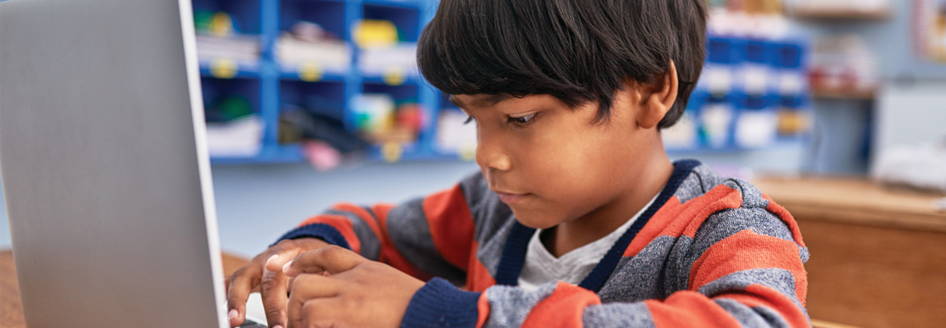young student using a laptop in classroom