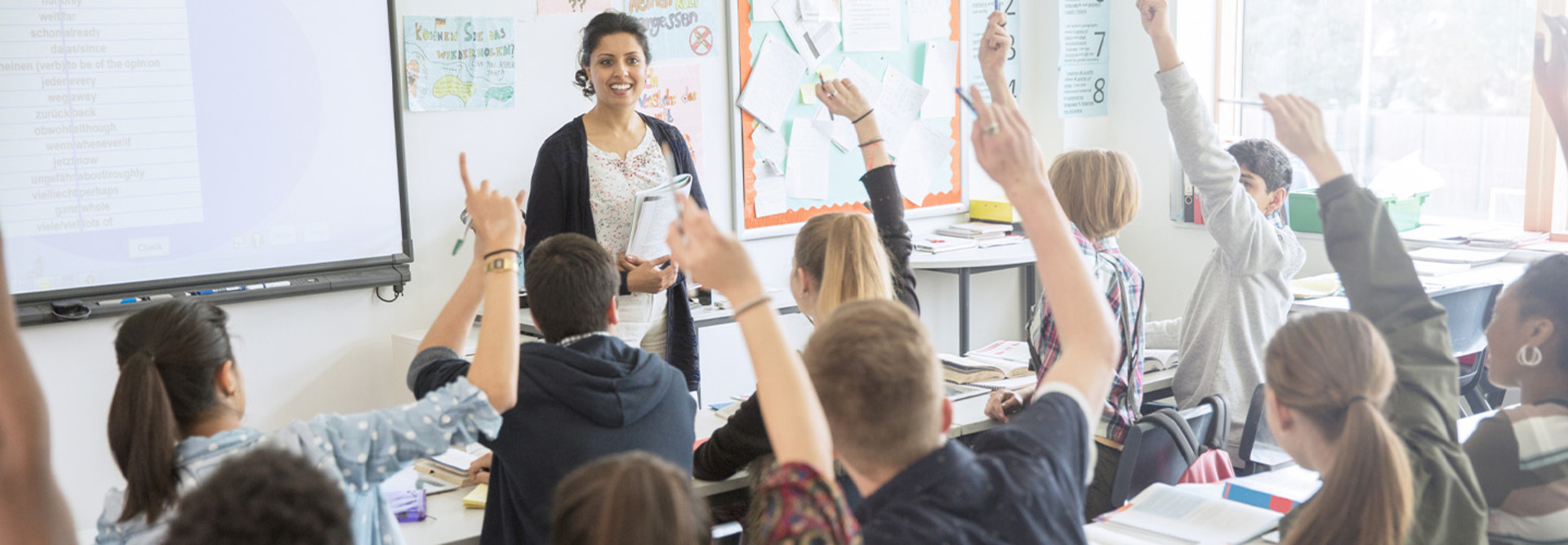 Students raising hands in class