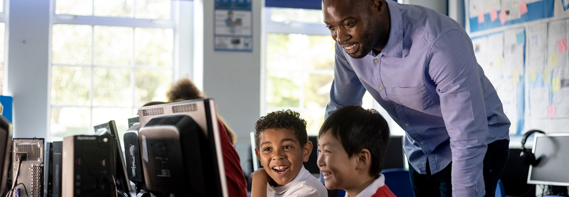 Teacher working with students at computer