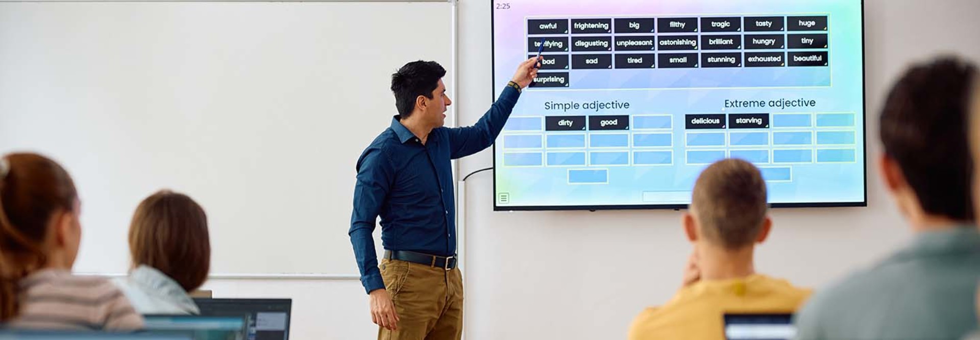 High school teacher using smartboard while teaching students in the classroom.