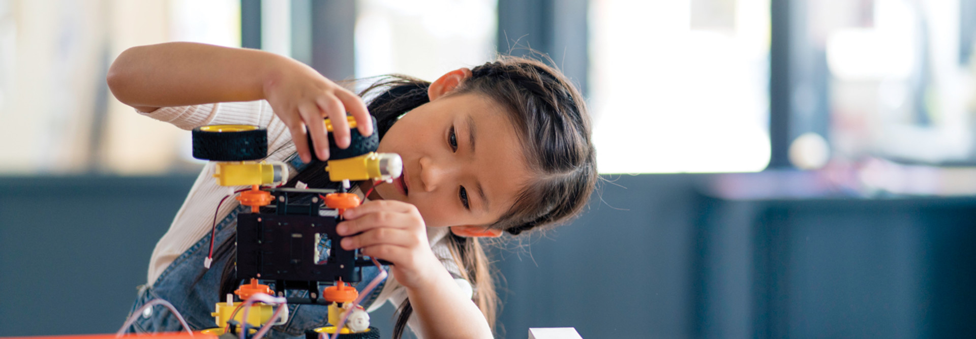 K–12 student building a robot with wheels