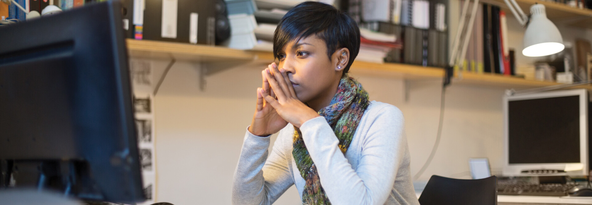 IT person mulling over information while sitting at desktop computer