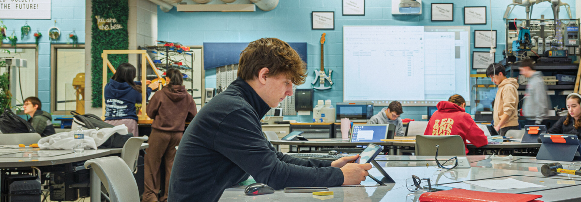 Student in a classroom working on a tablet at a table
