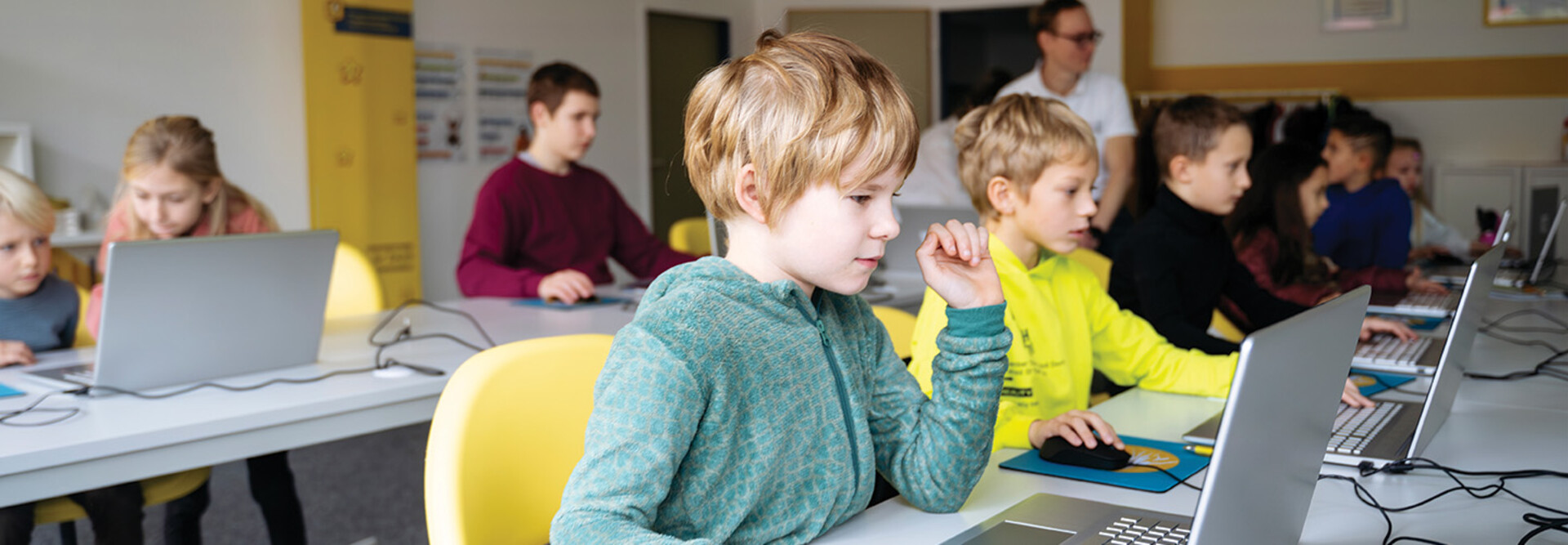 students on laptops in classroom