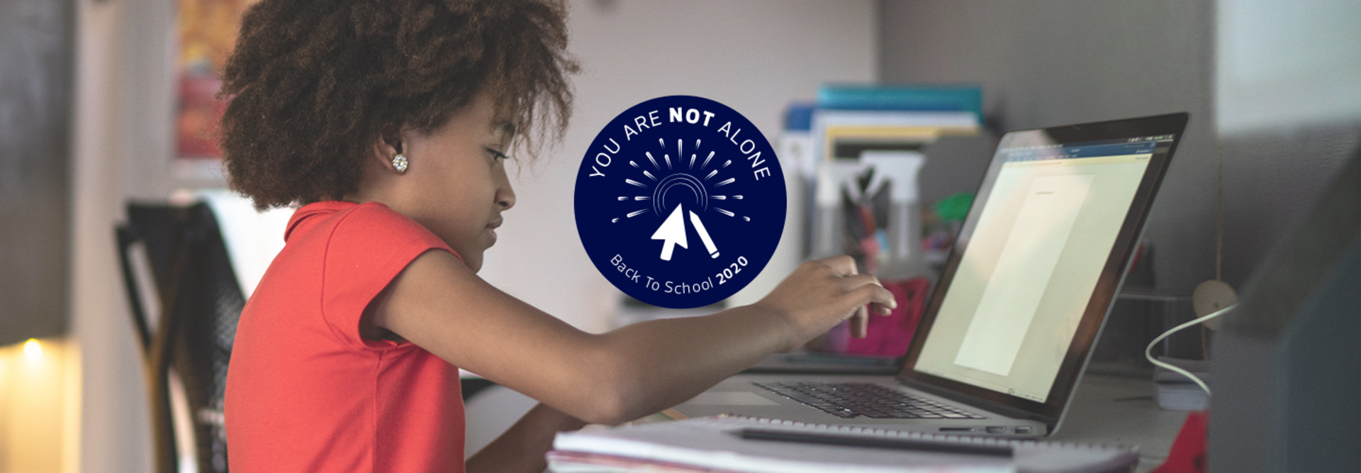 young girl using laptop for schoolwork at home