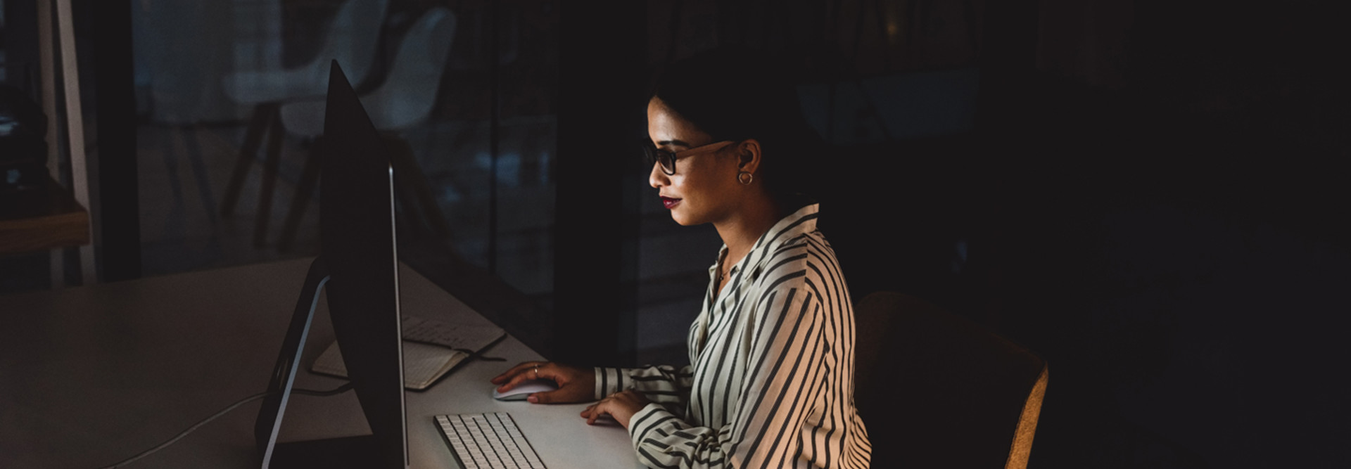 IT leader in front of computer screen in dark room cybersecurity