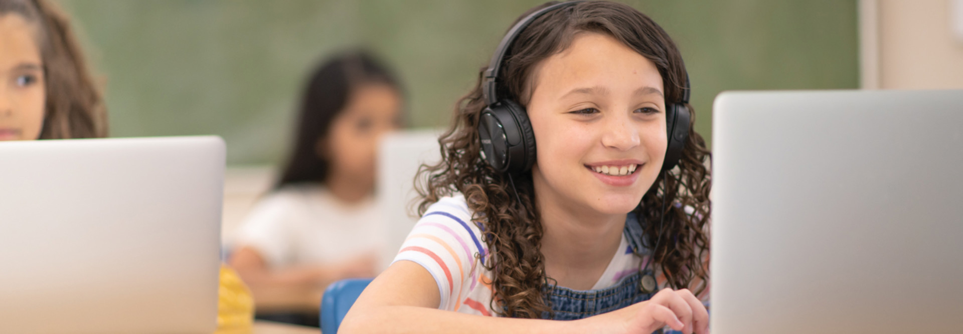 Digital Transformation - students using laptops and headphones in classroom