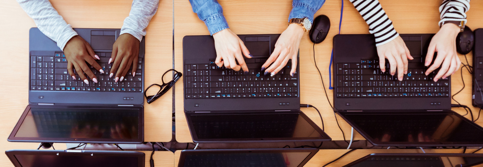 Students typing on laptops birds-eye view