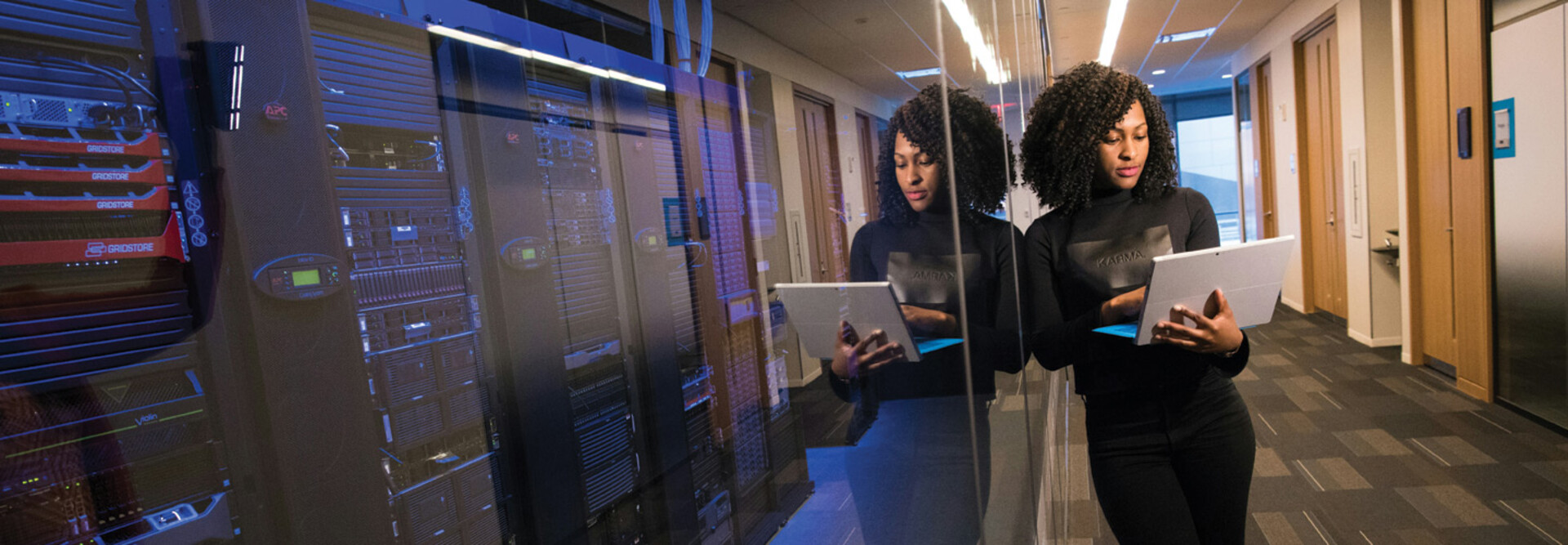 IT leader using a laptop computer next to servers