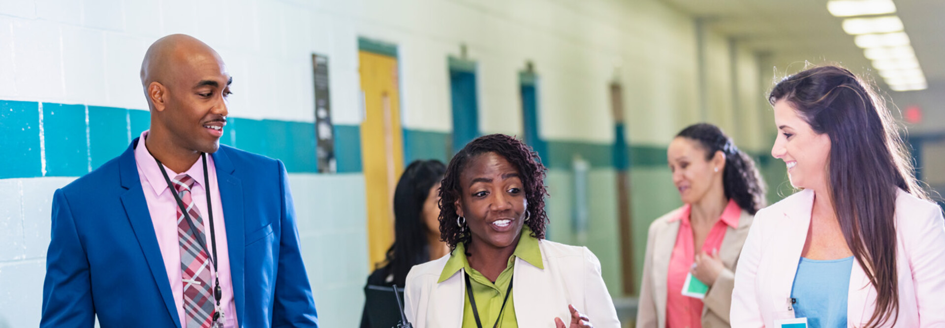Diverse group of educators walking in hallway
