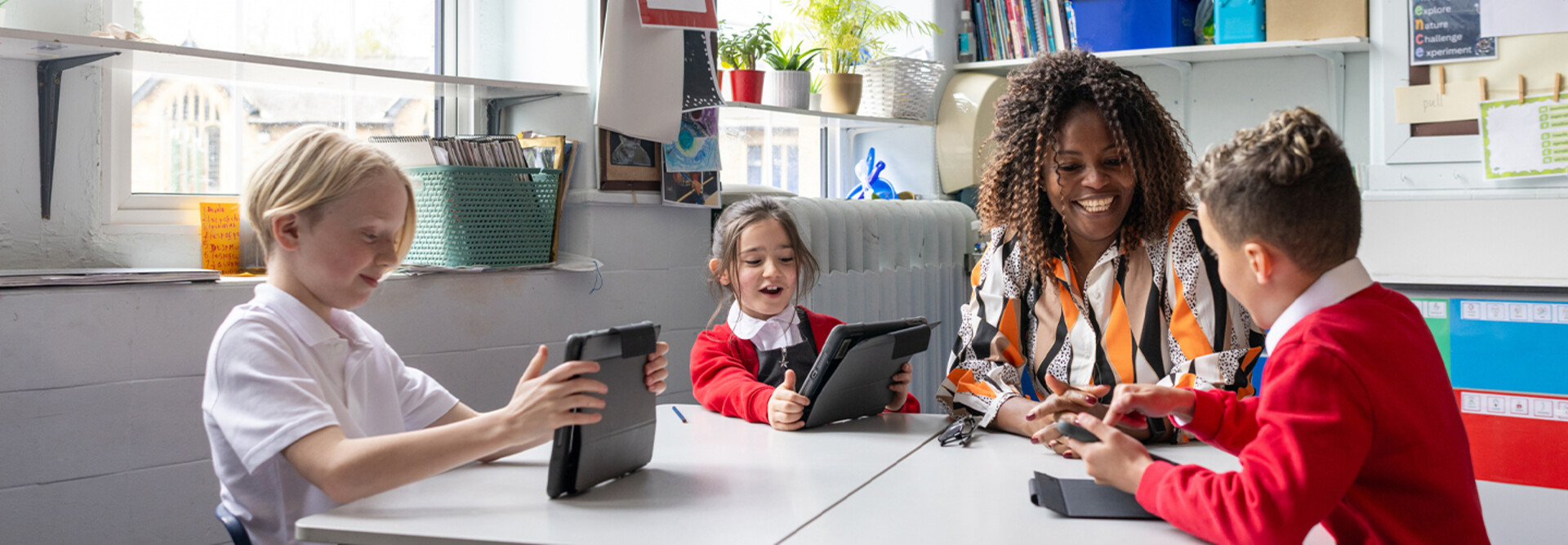Teacher helping students using tablets