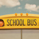 The front of a school bus against a cloudy sky