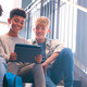 K12 students using tablet on school stairwell with great wi-fi