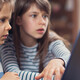 Two K–12 students working on a school laptop together