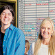 People in a classroom in front of a radio station scheduling board