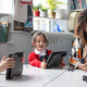 Teacher helping students using tablets