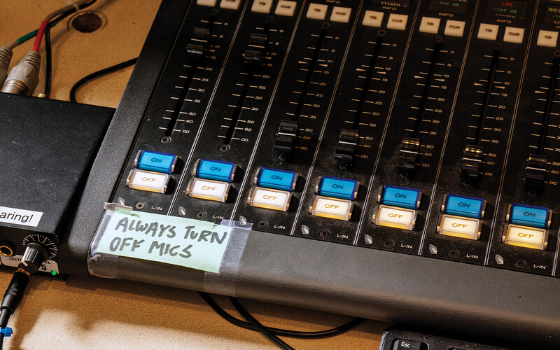 Sound board with a sign on it that reads "Always turn off mics"