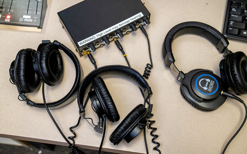 Three wired headsets set on a table