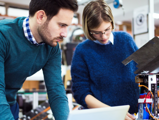 Teacher and student working on machine