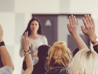 Teachers raising their hands in a training seminar
