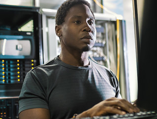 system admin man working in data center with laptop