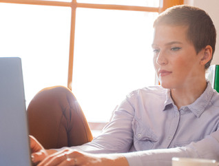IT leader on her laptop in front of a bright window