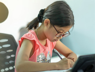 Young girl sitting at desk doing schoolwork