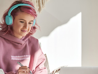 High school student using laptop and headphones at home