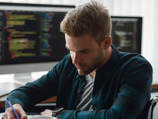 Man working with data on desktop and laptop computers
